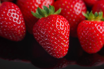Beautiful strawberry closeup with reflection. Macro image of fresh strawberries