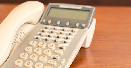 closeup old office telephone on the desk for business communication, multi language retro interior...
