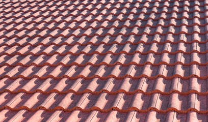 Red clay tile roof of real estate house, corrugate pattern row detail in exterior architecture construction element background