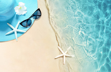 Obraz premium Hat and sunglasses on the sandy beach. Summer background
