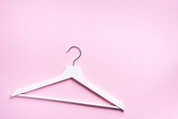 Top view of white clothes hangers on pink background with copy space. Flat lay. Minimalism style. Creative layout. Fashion, store sale, shopping concept. Banner for feminine blog