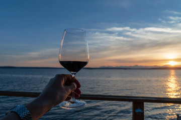 Cheers wine in hand at sunset on sea view deck - Powered by Adobe