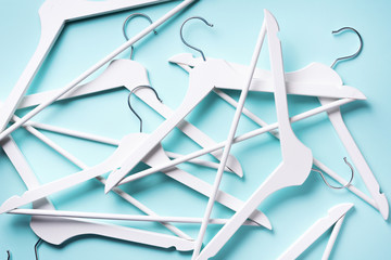 Top view of white clothes hangers on blue background with copy space. Flat lay. Minimalism style....