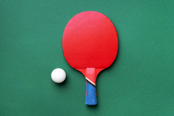 Sport, fitness, healthy lifestyle concept. Ping-pong or table tennis rackets and white ball on green background. Top view. Flat lay.
