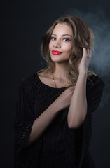 Beautiful ,young blonde with bright red lips and expressive eyes in a black jumpsuit. Beauty portrait of a girl. Emotional and bright appearance. Fashion portrait of a woman.