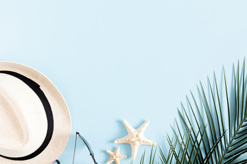 Summer modern composition. Tropical palm leaves, hat, starfish, sunglasses on blue background....