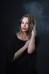 Beautiful ,young blonde with bright red lips and expressive eyes in a black jumpsuit. Beauty portrait of a girl. Emotional and bright appearance. Fashion portrait of a woman.