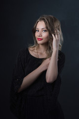 Beautiful ,young blonde with bright red lips and expressive eyes in a black jumpsuit. Beauty portrait of a girl. Emotional and bright appearance. Fashion portrait of a woman.