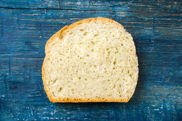 Slice of homemade bread on wooden background.