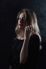 Fototapeta premium Beautiful ,young blonde with bright red lips and expressive eyes in a black jumpsuit. Beauty portrait of a girl. Emotional and bright appearance. Fashion portrait of a woman.