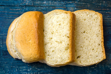 Slices of homemade bread on wooden background.