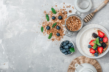 Healthy breakfast with granola, yogurt, fruits, berries on white background.