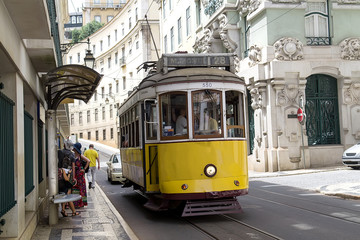 Fototapeta na wymiar Vintage yellow tramway in the city center of Lisbon. One of the main tourist attractions