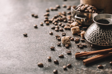 Coffee cup and coffee beans on dark stone background.