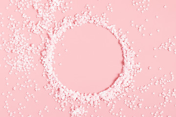 Festive light pink elegant background.  Round frame and stars on pastel pink background. Christmas, New Year, birthday concept. Flat lay, top view, copy space 