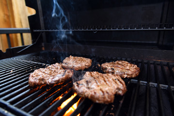 Grilling burgers on a barbecue with smoke