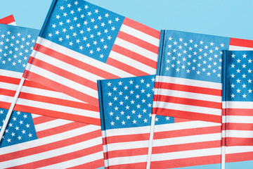 close up view of decorative american flags on sticks on blue background