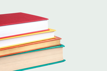 The concept of knowledge, library. Books yellow, red, green on a white background, stacked one on the other.