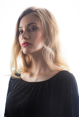 Naklejka premium Beautiful ,young blonde with bright red lips and expressive eyes in a black jumpsuit. Beauty portrait of a girl. Emotional and bright appearance. Fashion portrait of a woman.