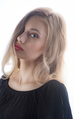 Fototapeta premium Beautiful ,young blonde with bright red lips and expressive eyes in a black jumpsuit. Beauty portrait of a girl. Emotional and bright appearance. Fashion portrait of a woman.