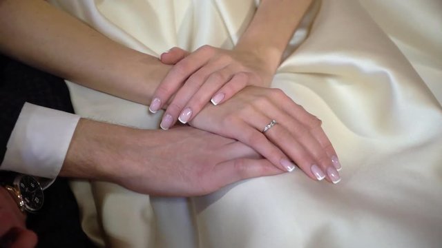 Bride and groom holding hands indoors