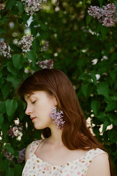 Young woman with lilac flower as an earring