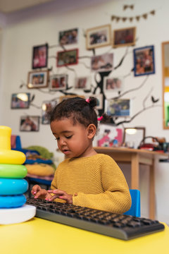 Cute girl playing with toys in the kindergarten. Childhood Concept.