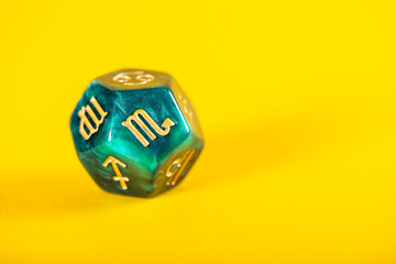 Astrology Dice with zodiac symbol of Scorpio Oct 23 - Nov 21 on Yellow Background