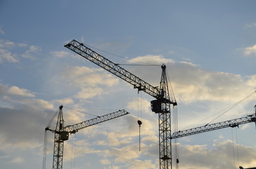 Fototapeta na wymiar Construction crane near the building under construction. Close up of a construction crane. Self-erection crane. Construction site