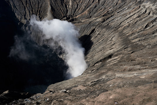 Mount Bromo active volcano crater with smoke from lava.