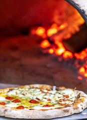 delicious pizza being roasted in traditional wood oven