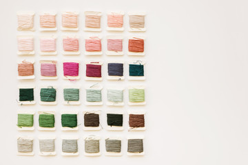 colorful embroidery thread arranged on a white background