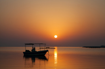 Fototapeta na wymiar Sunrise at Asker beach with a boat, Bahrain