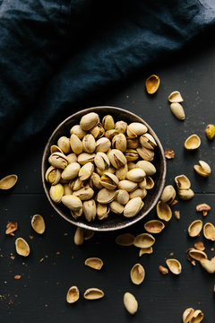 Overhead of bowl of pistachio nuts in shells