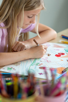 Child drawing with color pencils