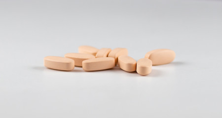 orange long pills capsules of vitamins for health on a white background