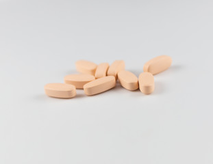 orange long pills capsules of vitamins for health on a white background