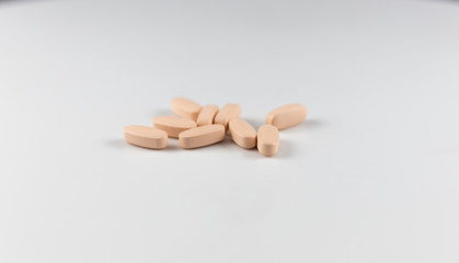 Fototapeta na wymiar orange long pills capsules of vitamins for health on a white background