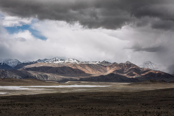 Scenic view of snowcapped mountain range against cloudy sky