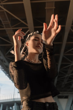 Young woman dancing under bridge