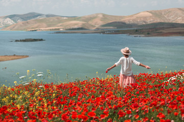 Young woman in a field of poppies.