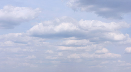 Fluffy white clouds on moody stormy sky 
