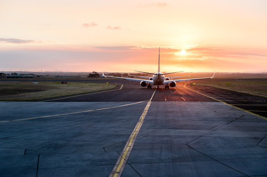 Queuing to enter the runway at an airport at sunset