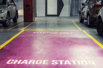 Electric car charging station in underground indoor parking of mall or office building. Reserved parking lot for environment friendly green energy zero emiision vehicles with fast charger plugs © Kirill Gorlov