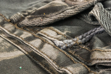 clothing items stonewashed cotton fabric texture with seams, clasps, buttons and rivets, macro