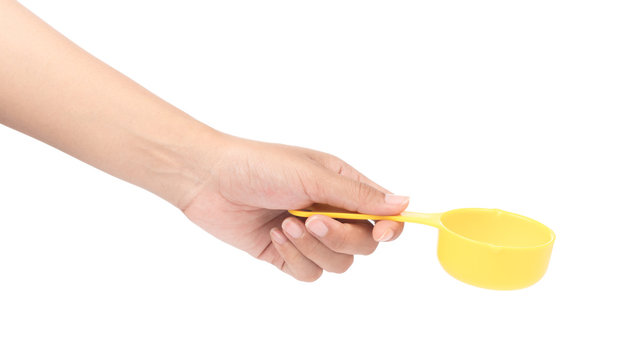 hand holding yellow plastic scoop isolated on white background