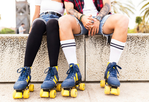 Couple's legs wearing roller skates in the street.