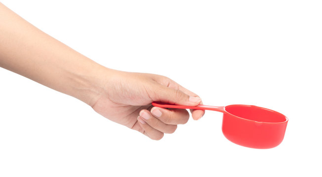 hand holding red plastic scoop isolated on white background