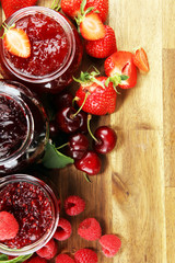 assortment of jams, seasonal berries, cherry, mint and fruits in glass jar