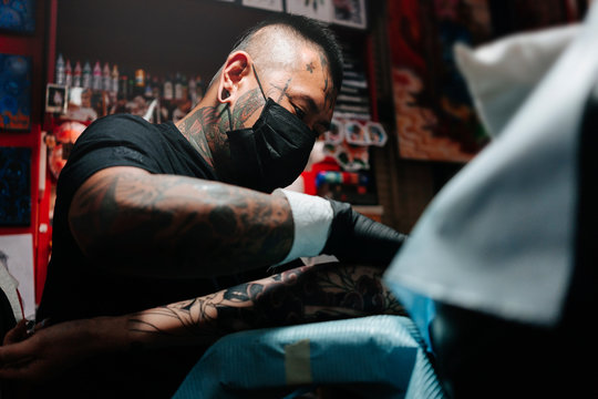 Professional asian tattooer makes a tattoo